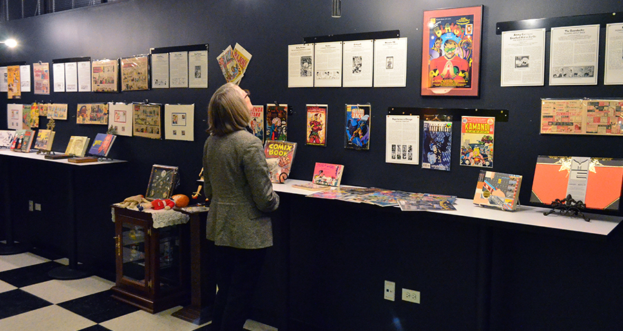 Woman examining the Comics Exhibit placards on the wall